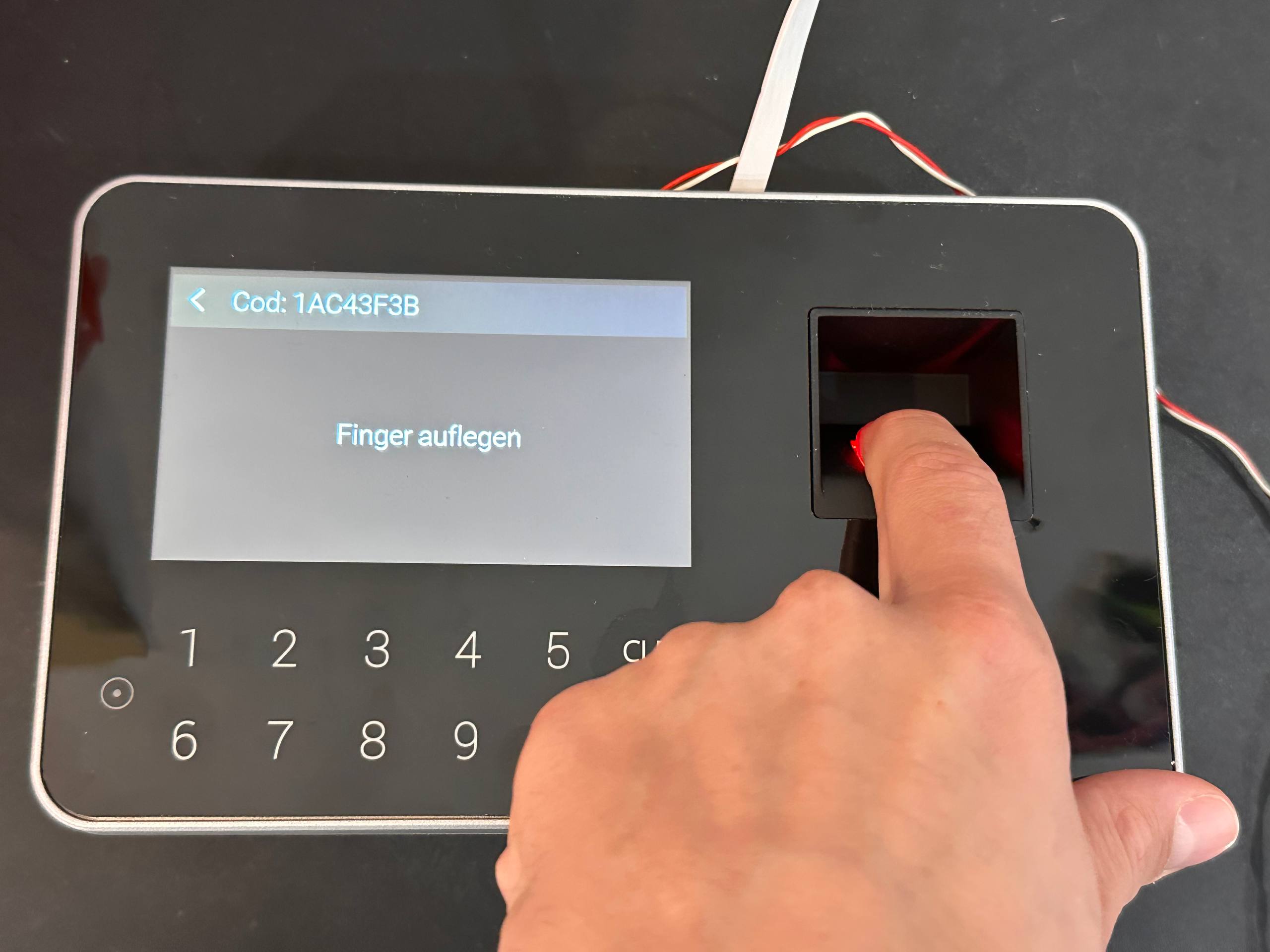 Bild 9: Finger auf den beleuchteten Fingerabdrucksensor rechts neben dem Display legen.