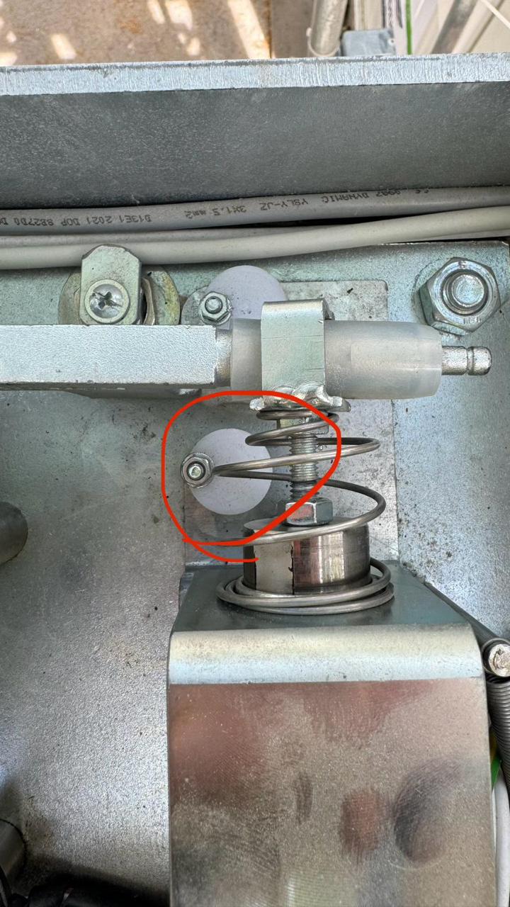 Mechanism with hex nut and spring - the marked spot shows the nut that must be turned first